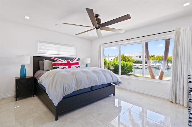 tiled bedroom featuring a water view and ceiling fan