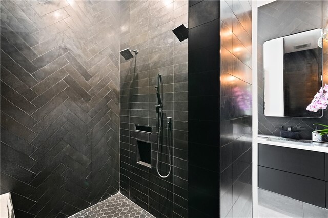 bathroom with tile walls, vanity, and tiled shower