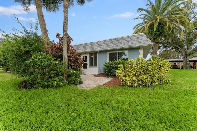 3361 Scorecard Dr Unit 0, New Port Richey, FL 34655 - back of house featuring a yard, a shingled roof, and stucco siding