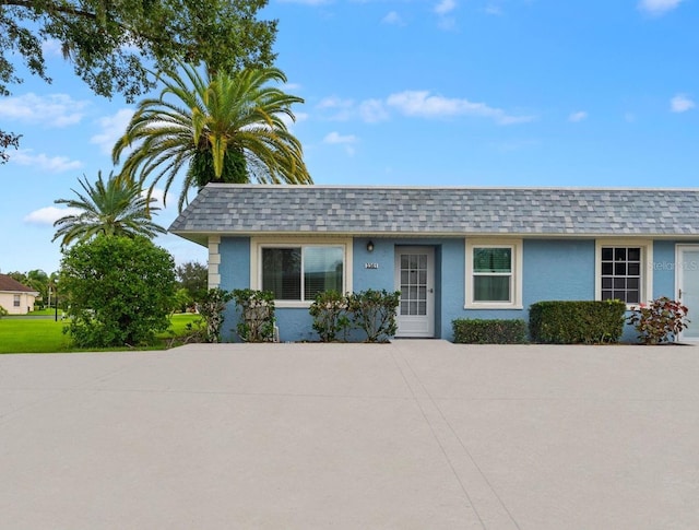 3361 Scorecard Dr Unit 0, New Port Richey, FL 34655 - view of front of home with a shingled roof, stucco siding, and mansard roof
