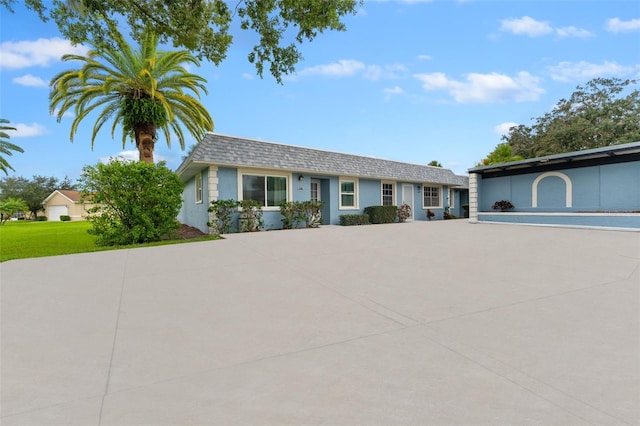 3361 Scorecard Dr Unit 0, New Port Richey, FL 34655 - view of front of house with stucco siding, a front lawn, and roof with shingles