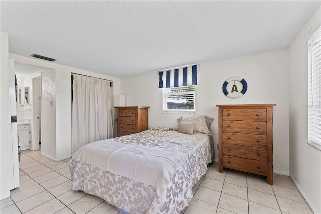 3361 Scorecard Dr Unit 0, New Port Richey, FL 34655 - bedroom with light tile patterned floors, multiple windows, a textured ceiling, and baseboards