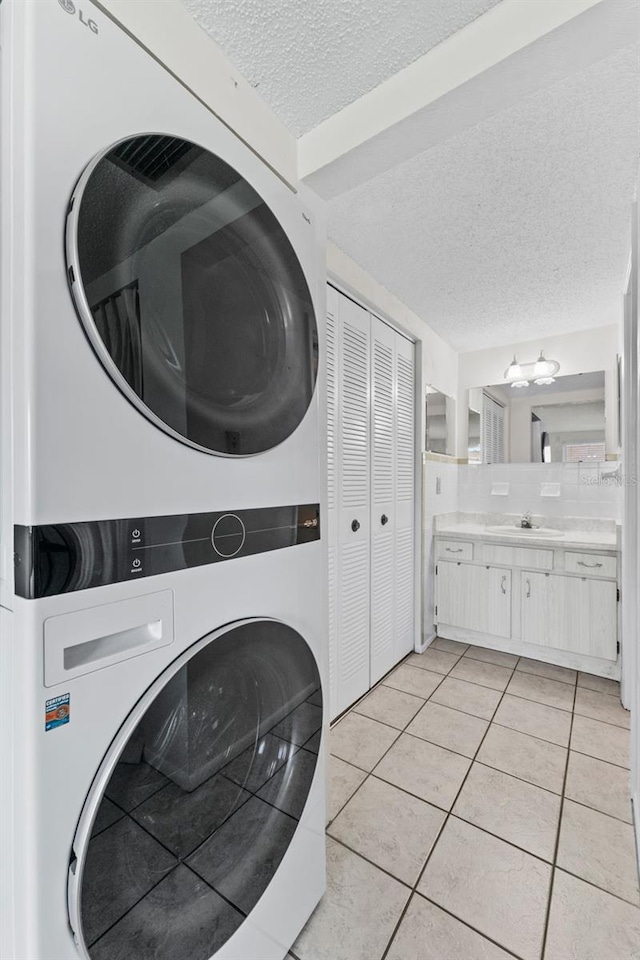 3361 Scorecard Dr Unit 0, New Port Richey, FL 34655 - laundry room featuring stacked washer / drying machine, a textured ceiling, and light tile patterned flooring
