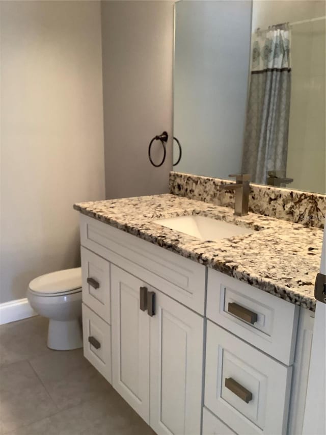 bathroom featuring tile patterned flooring, vanity, and toilet