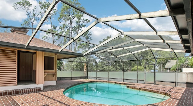 view of pool with a patio and glass enclosure