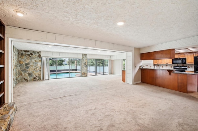 unfurnished living room featuring light colored carpet and a textured ceiling