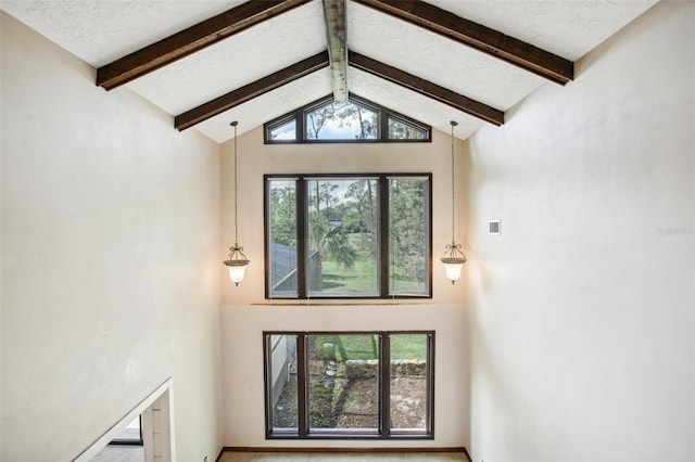 doorway featuring beam ceiling and high vaulted ceiling