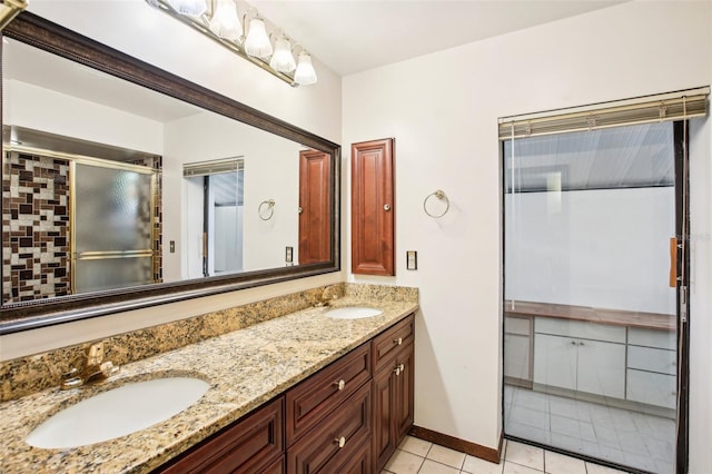 bathroom featuring backsplash, tile patterned flooring, vanity, and a shower with shower door