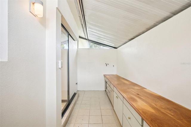 interior space featuring light tile patterned flooring and lofted ceiling