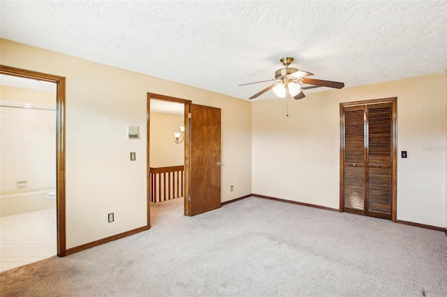 unfurnished bedroom featuring a textured ceiling, light colored carpet, ceiling fan, connected bathroom, and a closet