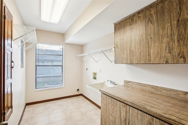 washroom with hookup for an electric dryer, hookup for a washing machine, light tile patterned floors, and cabinets