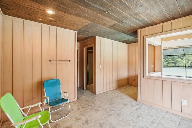 additional living space with wood ceiling and wood walls