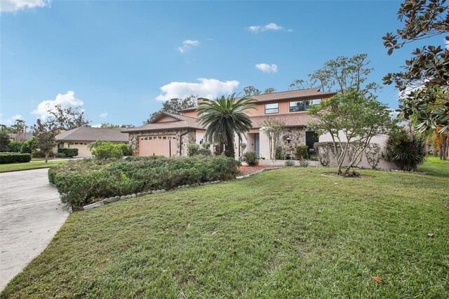 mediterranean / spanish-style home with a garage and a front lawn