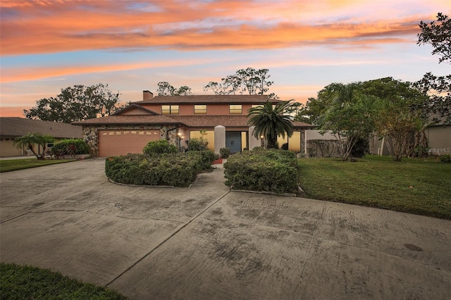 view of front of property with a yard and a garage