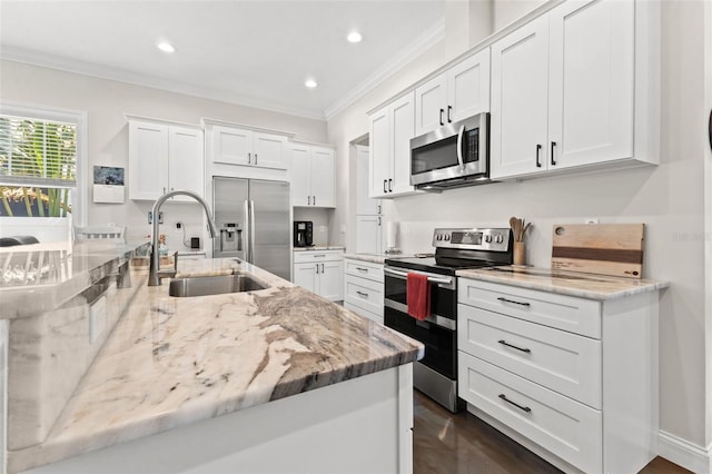 kitchen with light stone counters, stainless steel appliances, crown molding, sink, and white cabinetry