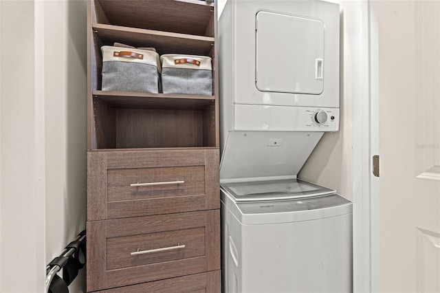 clothes washing area featuring stacked washer / dryer