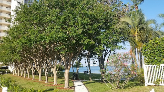 surrounding community with a yard and a water view