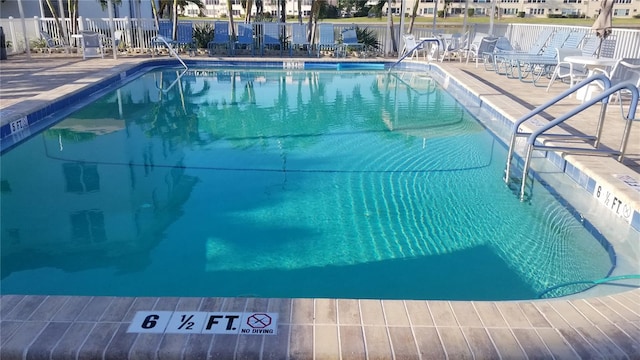 community pool featuring fence and a patio