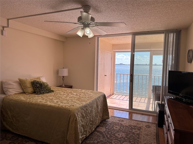 bedroom with access to exterior, wood-type flooring, a textured ceiling, and ceiling fan