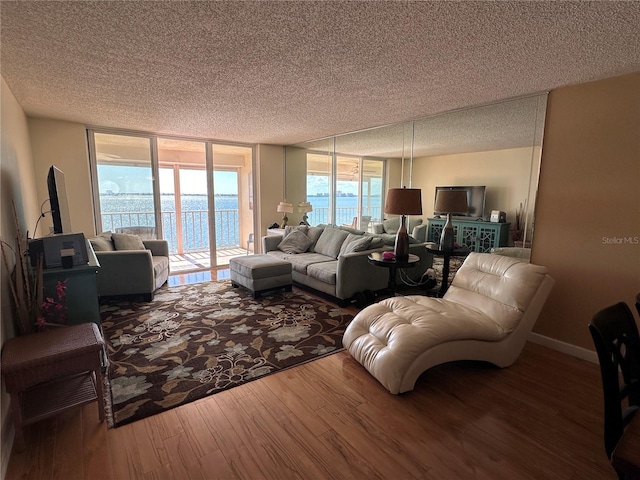 living room featuring a textured ceiling, hardwood / wood-style flooring, and floor to ceiling windows