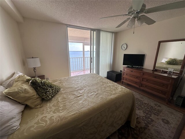 bedroom with access to outside, a textured ceiling, and ceiling fan