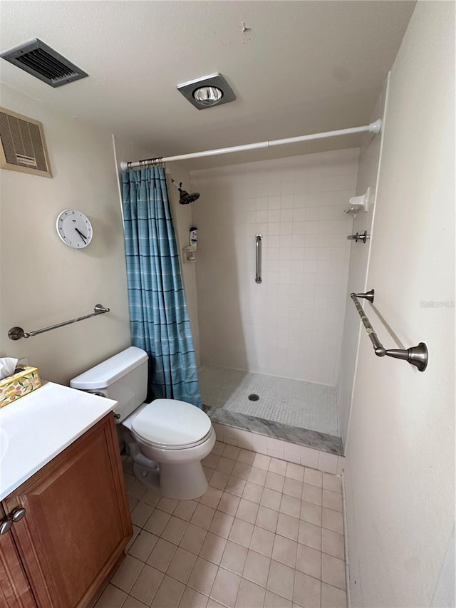 bathroom with tile patterned floors, tiled shower, toilet, and vanity