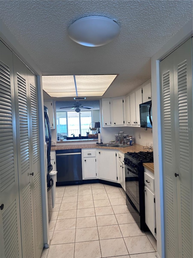 kitchen with black appliances, a textured ceiling, light tile patterned floors, white cabinets, and a ceiling fan