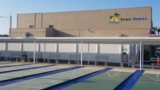 surrounding community featuring covered parking and shuffleboard