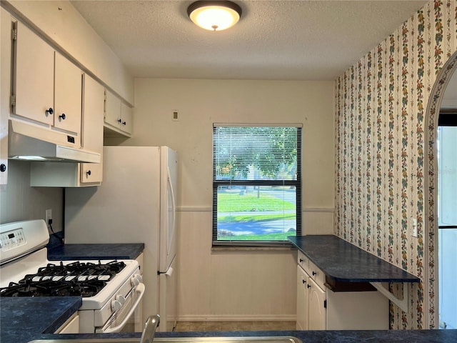 kitchen with white cabinets, a textured ceiling, and gas range gas stove