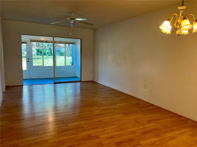 spare room featuring light hardwood / wood-style floors and ceiling fan with notable chandelier