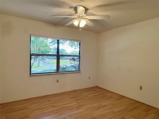 spare room with light wood-type flooring and ceiling fan