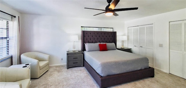 carpeted bedroom featuring two closets and ceiling fan