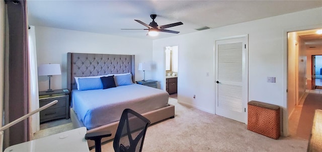 carpeted bedroom featuring ensuite bathroom, ceiling fan, and a closet