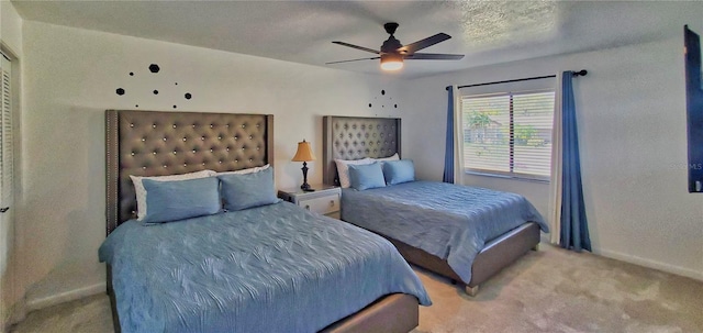 bedroom with ceiling fan, a textured ceiling, and light colored carpet