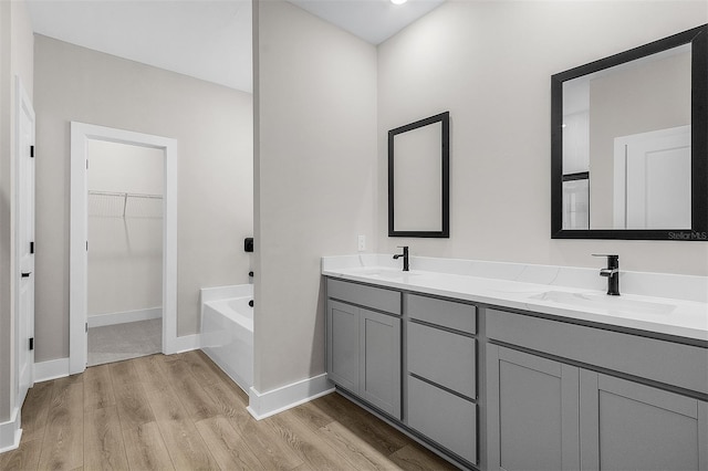 bathroom featuring wood-type flooring, vanity, and a bathtub