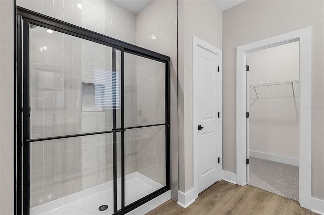 bathroom featuring a shower with door and hardwood / wood-style floors