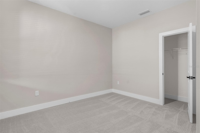 unfurnished bedroom featuring light colored carpet and a closet