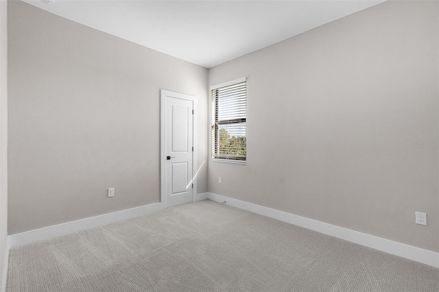 unfurnished room featuring light carpet