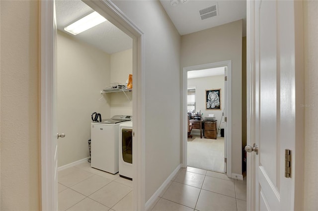 laundry area featuring light tile patterned flooring and separate washer and dryer