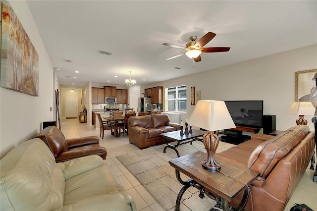 living room featuring ceiling fan with notable chandelier and light tile patterned floors