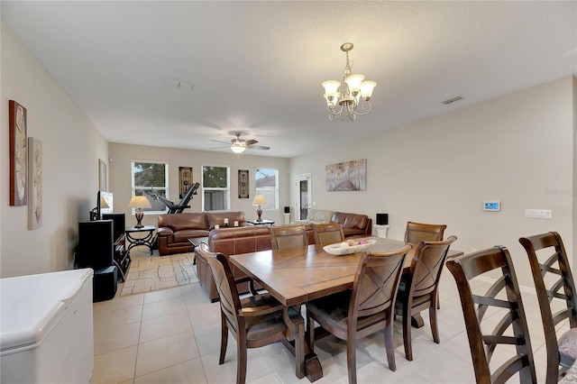 dining room with ceiling fan with notable chandelier and light tile patterned floors