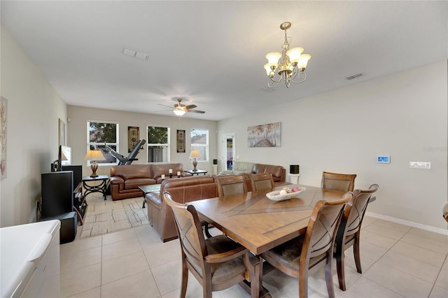 tiled dining space featuring ceiling fan with notable chandelier