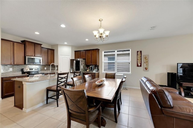 dining area with a chandelier and light tile patterned floors