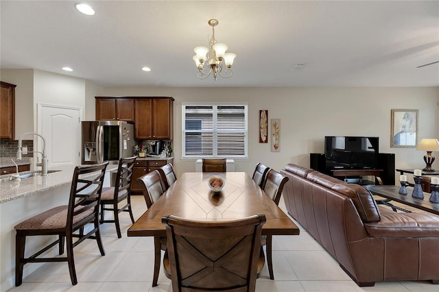 tiled dining area with sink and an inviting chandelier