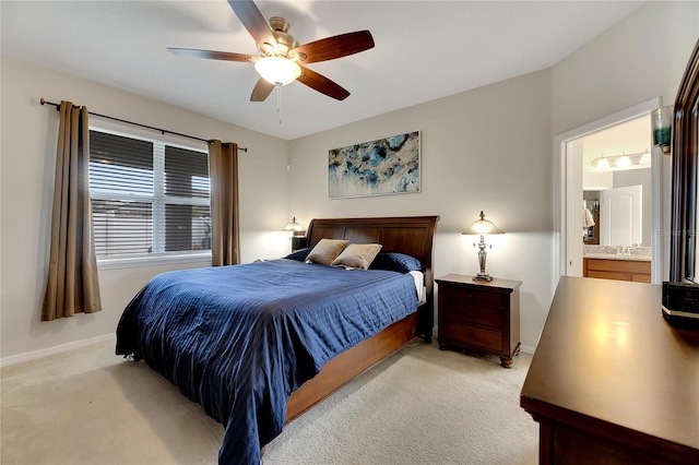 bedroom featuring ensuite bath, light carpet, and ceiling fan