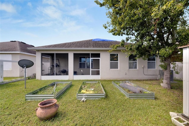 rear view of property featuring a sunroom and a lawn