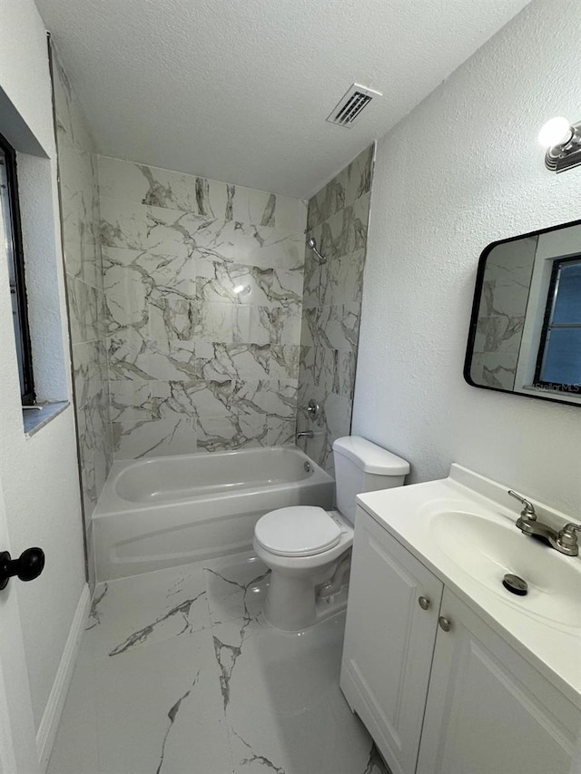 full bathroom featuring vanity, tiled shower / bath combo, a textured ceiling, and toilet