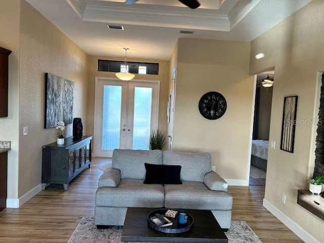 living room featuring french doors, hardwood / wood-style flooring, and ornamental molding