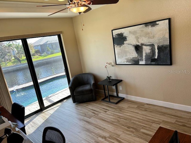 living area with light hardwood / wood-style flooring, lofted ceiling, and ceiling fan