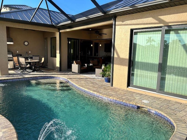 view of pool with ceiling fan, glass enclosure, a patio area, and an outdoor living space